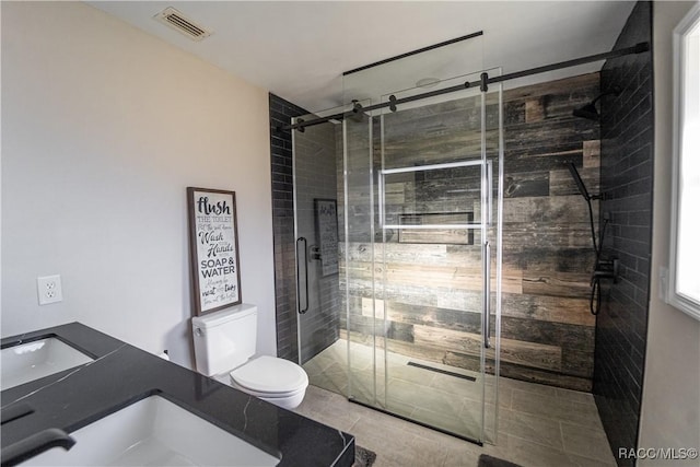 bathroom featuring tile patterned floors, vanity, an enclosed shower, and toilet