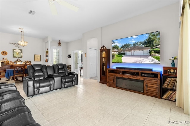 living room featuring light tile patterned flooring and ceiling fan with notable chandelier