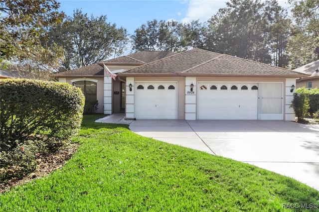 single story home with a garage and a front lawn