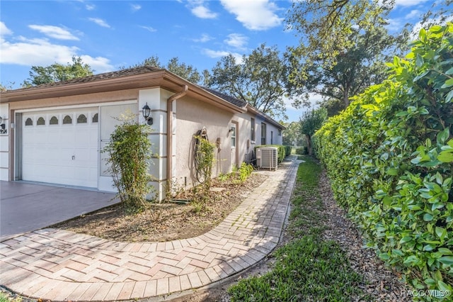 view of property exterior with central AC and a garage