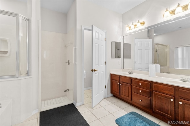 bathroom featuring tile patterned flooring, vanity, and a shower