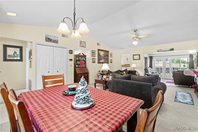 carpeted dining space featuring ceiling fan with notable chandelier, vaulted ceiling, and french doors