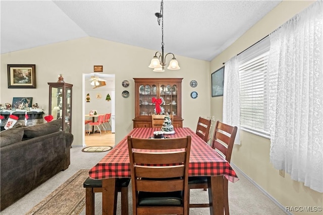 dining room featuring lofted ceiling, a textured ceiling, light carpet, and a notable chandelier