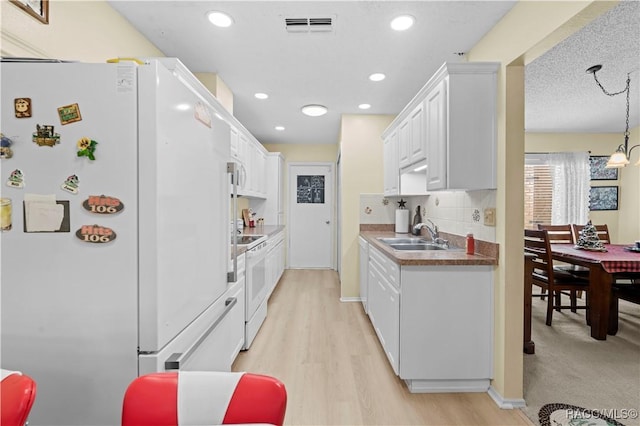 kitchen featuring white cabinetry, sink, decorative backsplash, white appliances, and light wood-type flooring