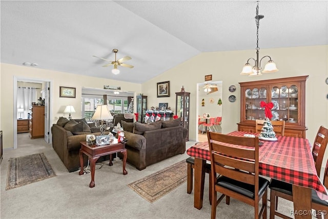 carpeted dining space featuring lofted ceiling and ceiling fan with notable chandelier