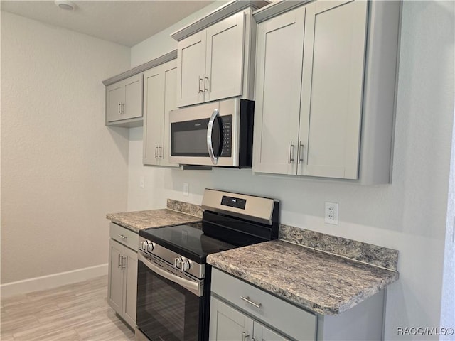 279 Bittern Loop, Inverness, FL 34453 - kitchen featuring baseboards, appliances with stainless steel finishes, gray cabinetry, and light wood finished floors