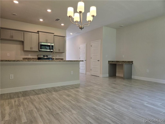 279 Bittern Loop, Inverness, FL 34453 - kitchen with appliances with stainless steel finishes, gray cabinetry, and light wood-style floors