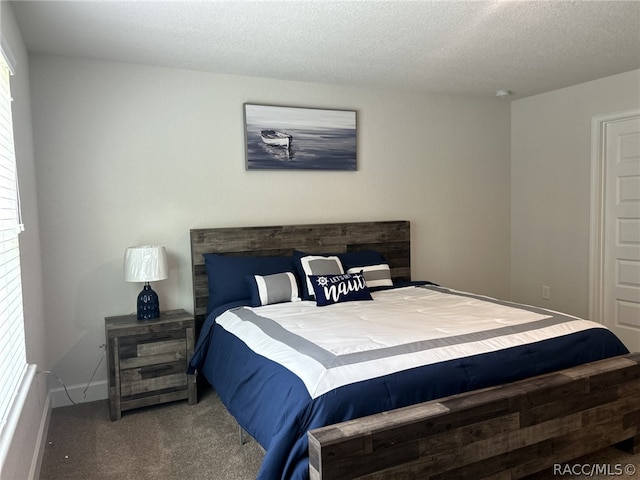 carpeted bedroom featuring a textured ceiling and multiple windows