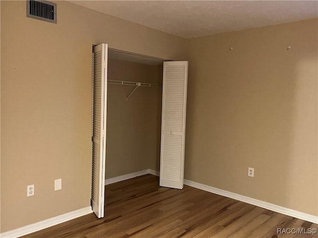 unfurnished bedroom with light wood-type flooring and a closet