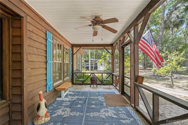 unfurnished sunroom featuring ceiling fan and a wealth of natural light