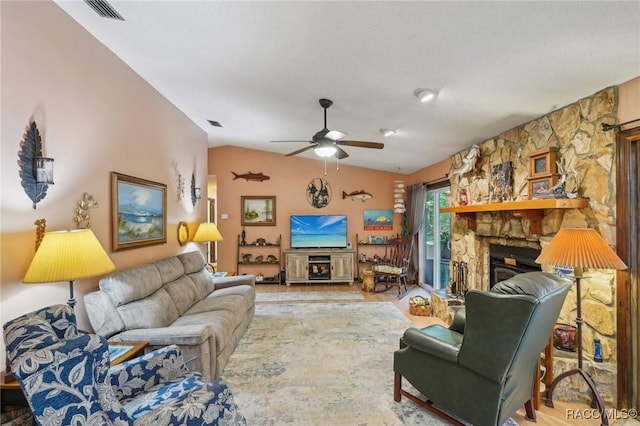 living room featuring visible vents, wood finished floors, a fireplace, ceiling fan, and vaulted ceiling