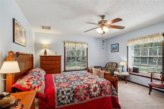 bedroom featuring carpet floors, multiple windows, a textured ceiling, and visible vents
