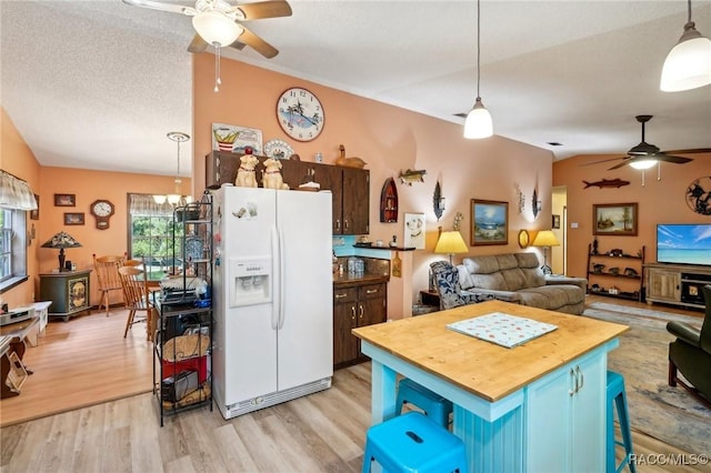 kitchen featuring blue cabinetry, ceiling fan with notable chandelier, light wood-style floors, wood counters, and white fridge with ice dispenser