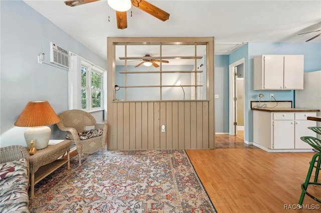 sitting room with a ceiling fan and light wood-style flooring