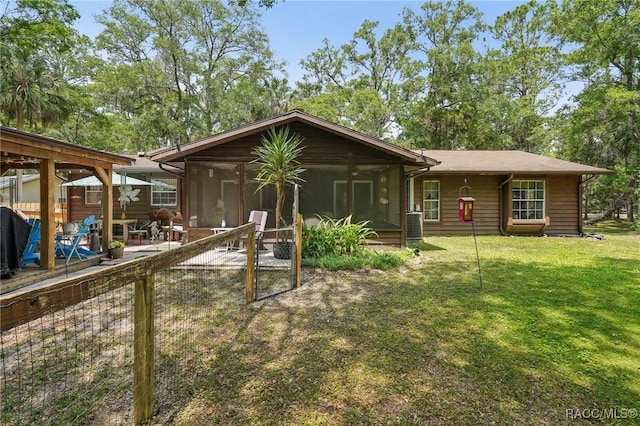 back of property with a yard, a patio, and a sunroom