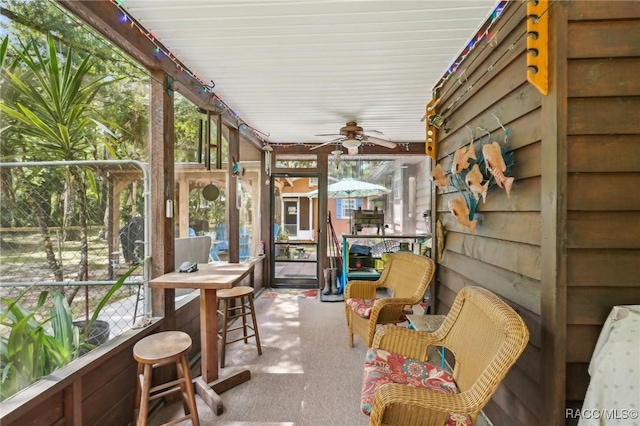 sunroom / solarium featuring a ceiling fan and plenty of natural light