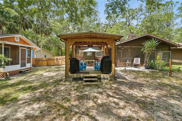 view of yard featuring fence, a sunroom, and a deck