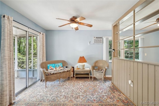 living area with carpet, a ceiling fan, and an AC wall unit