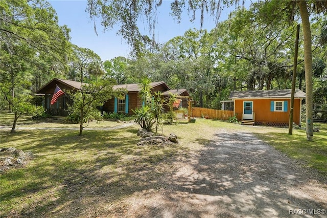 view of front of home featuring entry steps, fence, and a front yard