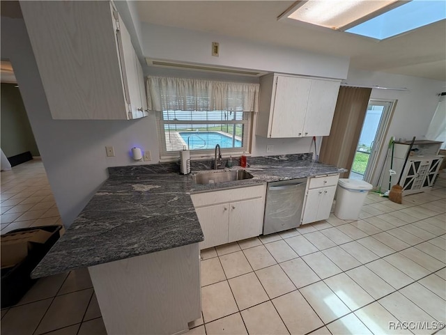 kitchen featuring stainless steel appliances, a skylight, light tile patterned flooring, and ceiling fan