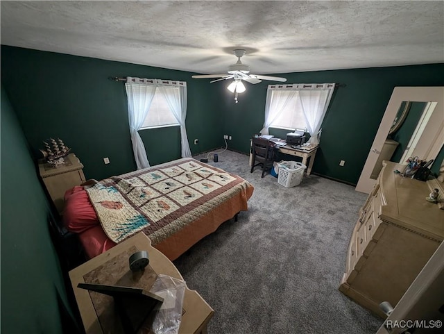 bedroom with multiple windows, carpet flooring, a textured ceiling, and a ceiling fan