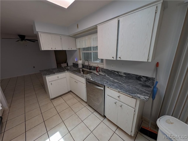 kitchen featuring stainless steel dishwasher, a sink, light tile patterned flooring, a peninsula, and ceiling fan