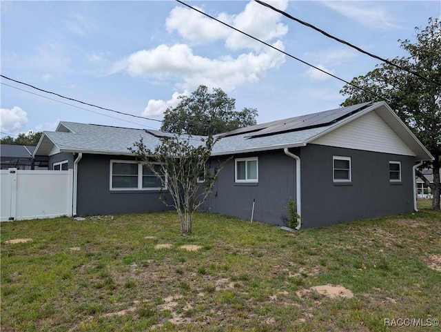 view of property exterior featuring stucco siding, solar panels, and roof with shingles