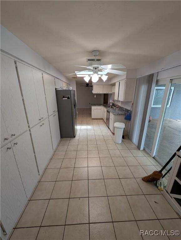 kitchen featuring stainless steel appliances, a ceiling fan, white cabinets, and a sink