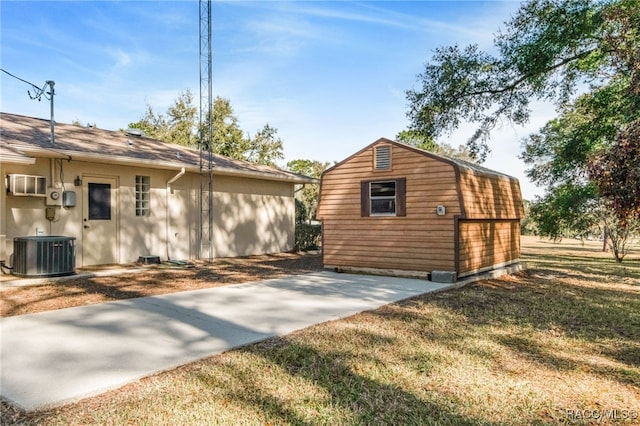 view of side of home with a yard, cooling unit, and an outdoor structure