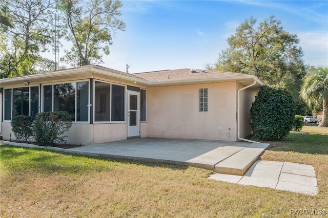 rear view of house with a patio area, a lawn, and a sunroom