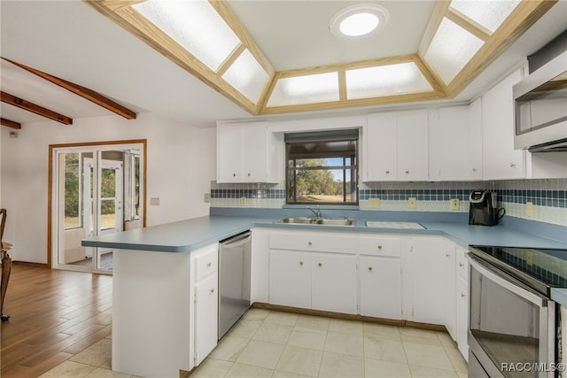 kitchen featuring kitchen peninsula, sink, white cabinetry, and appliances with stainless steel finishes