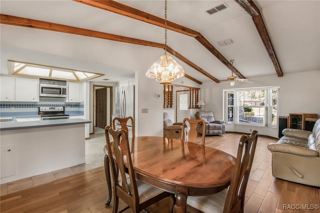 dining area featuring an inviting chandelier and lofted ceiling with beams