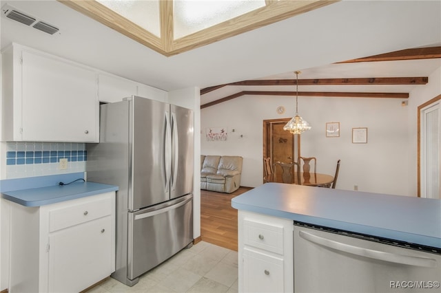 kitchen with tasteful backsplash, hanging light fixtures, white cabinets, vaulted ceiling with beams, and stainless steel appliances