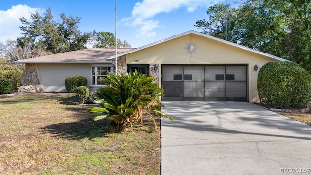 single story home featuring a garage and a front lawn