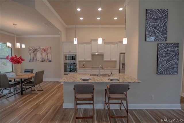 kitchen featuring light stone countertops, dark hardwood / wood-style flooring, white cabinets, and stainless steel appliances