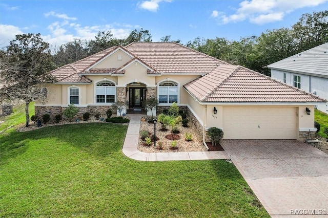 mediterranean / spanish-style home with a garage and a front yard