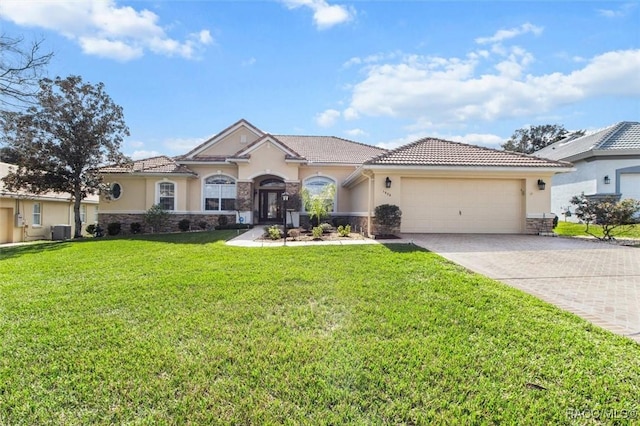 mediterranean / spanish house with a garage, a front yard, and central air condition unit