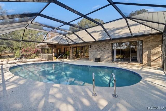 view of pool featuring a patio and glass enclosure