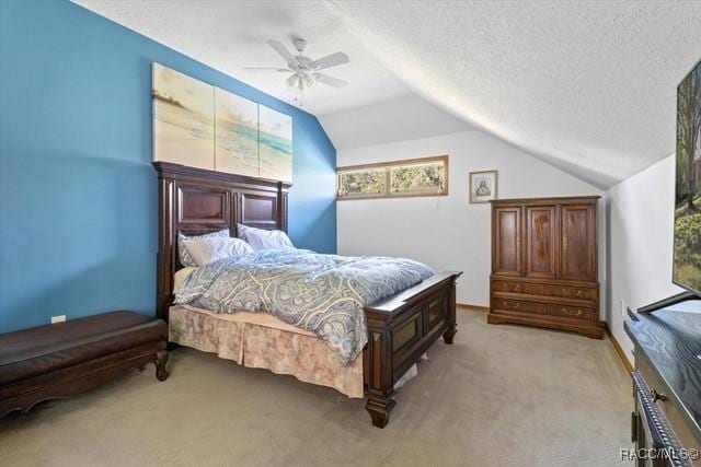 carpeted bedroom featuring a textured ceiling, vaulted ceiling, and ceiling fan