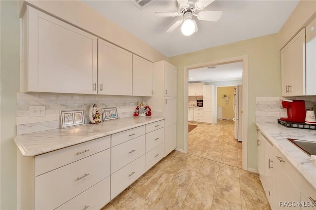 66 S Desoto St, Beverly Hills, FL 34465 - kitchen with freestanding refrigerator, decorative backsplash, white cabinetry, and a ceiling fan