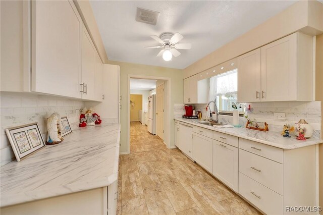 66 S Desoto St, Beverly Hills, FL 34465 - kitchen with a sink, backsplash, ceiling fan, and white cabinetry