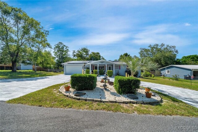 66 S Desoto St, Beverly Hills, FL 34465 - view of front of home with driveway, roof mounted solar panels, a front lawn, and an attached garage