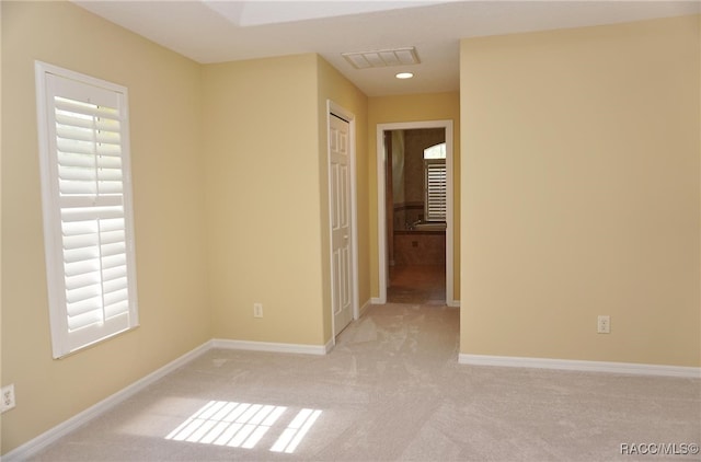 carpeted spare room featuring plenty of natural light