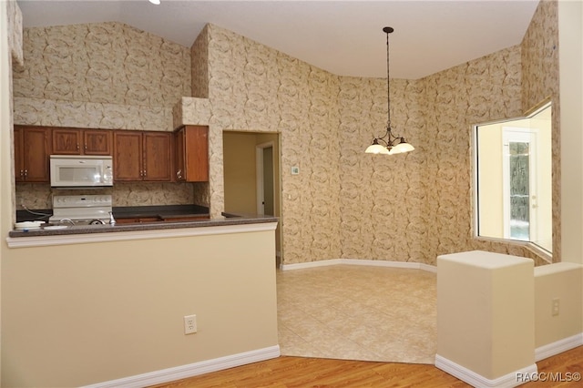 kitchen featuring hanging light fixtures, kitchen peninsula, lofted ceiling, white appliances, and light wood-type flooring