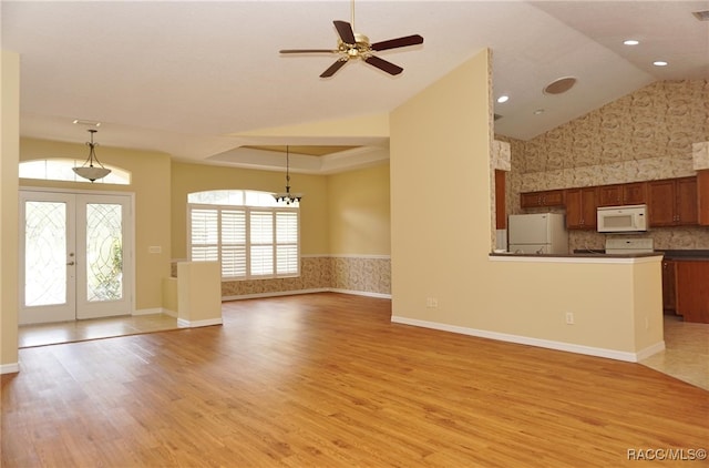 unfurnished living room with french doors, light hardwood / wood-style flooring, ceiling fan, and lofted ceiling