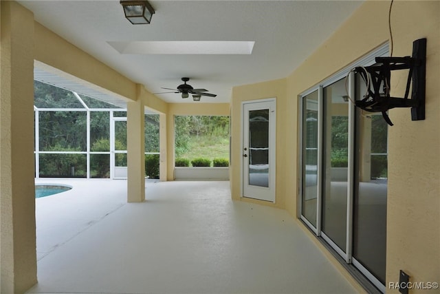 sunroom / solarium with ceiling fan and a pool