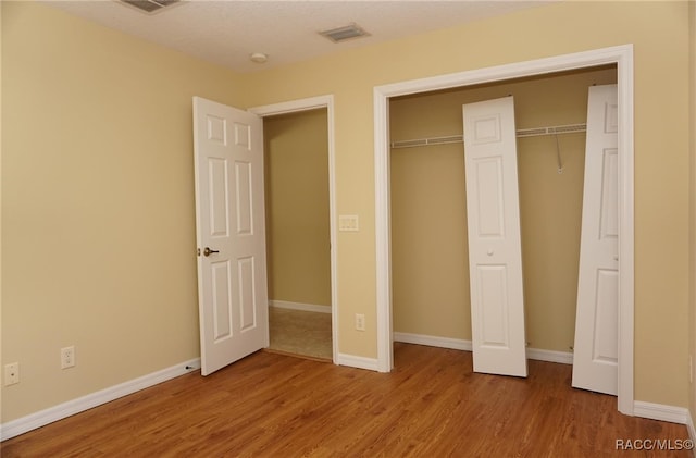 unfurnished bedroom featuring hardwood / wood-style floors and a closet