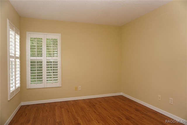 unfurnished room with hardwood / wood-style floors, a textured ceiling, and a wealth of natural light