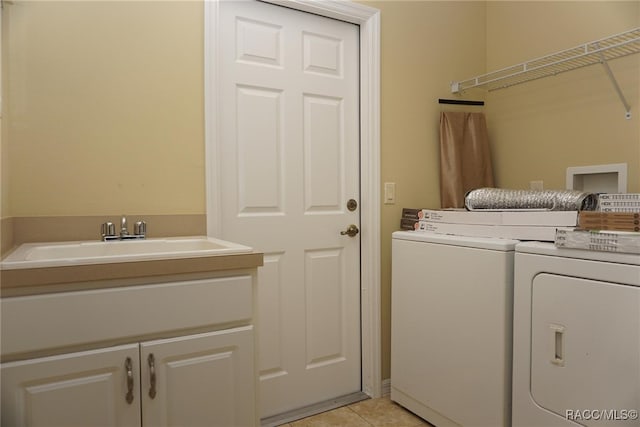 clothes washing area with sink, light tile patterned floors, cabinets, and independent washer and dryer