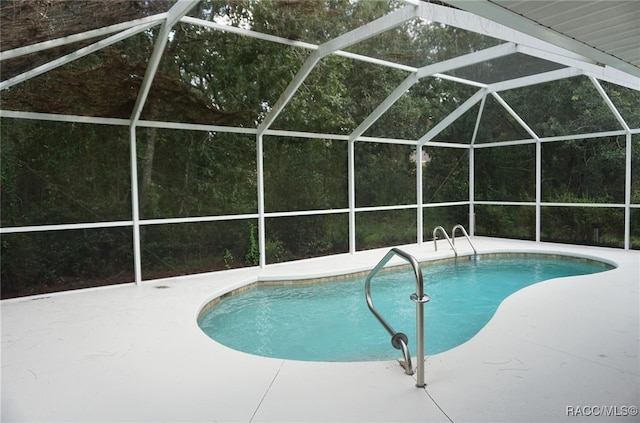 view of pool featuring glass enclosure and a patio